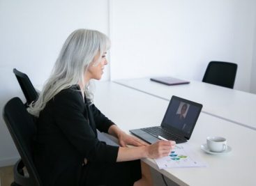 Friendly female office worker talking to colleague